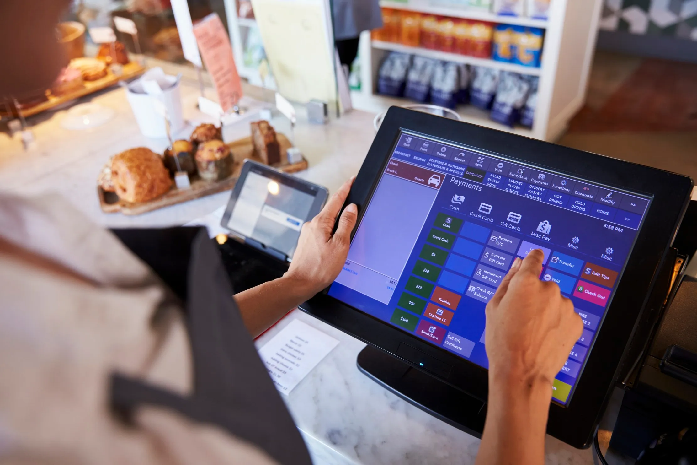 Shop employee working at a checkout counter, representing POS workflows, receipts, and daily sales control