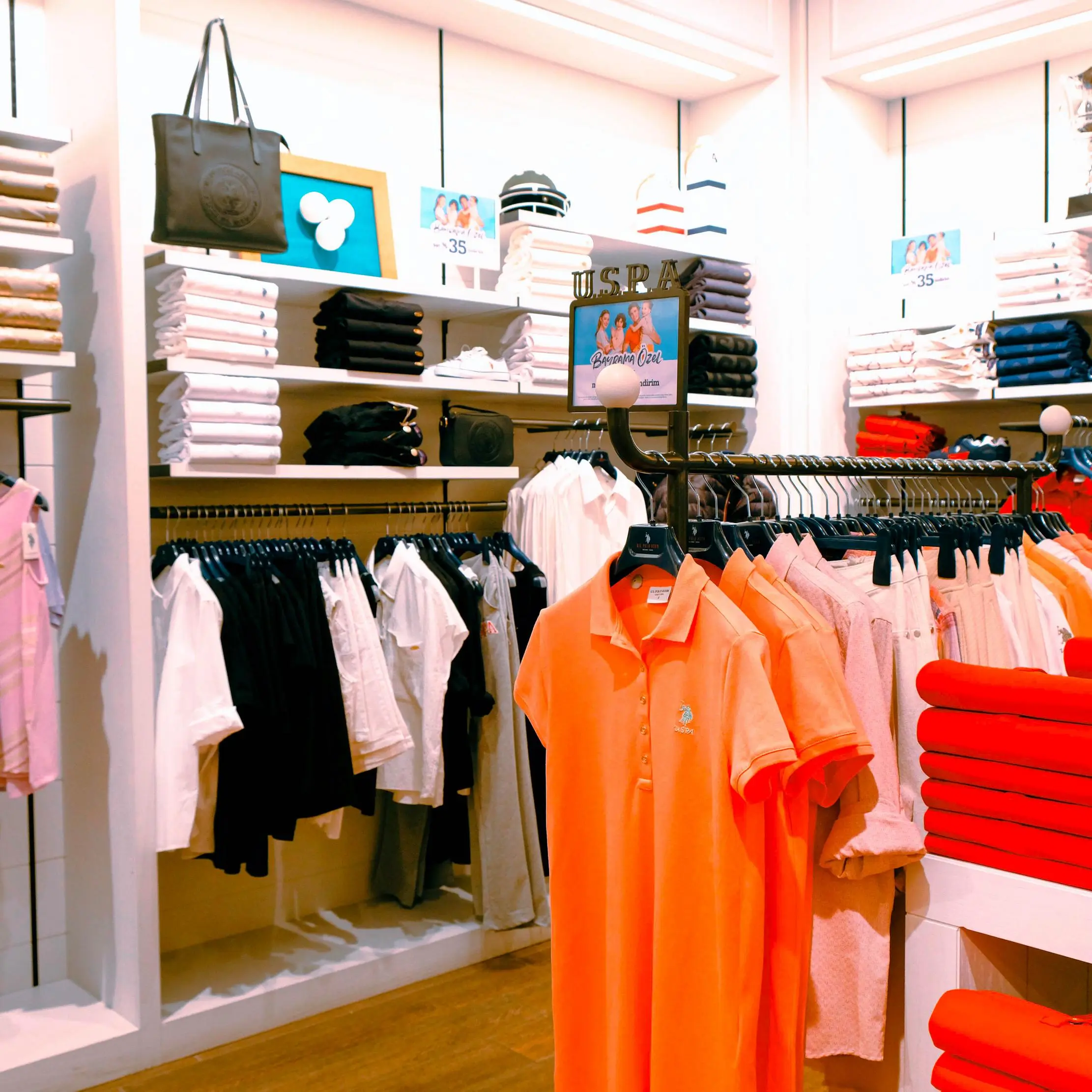 Présentoirs de vêtements dans une boutique de mode, illustrant les workflows Maduuka de tailles, variantes et catalogue
