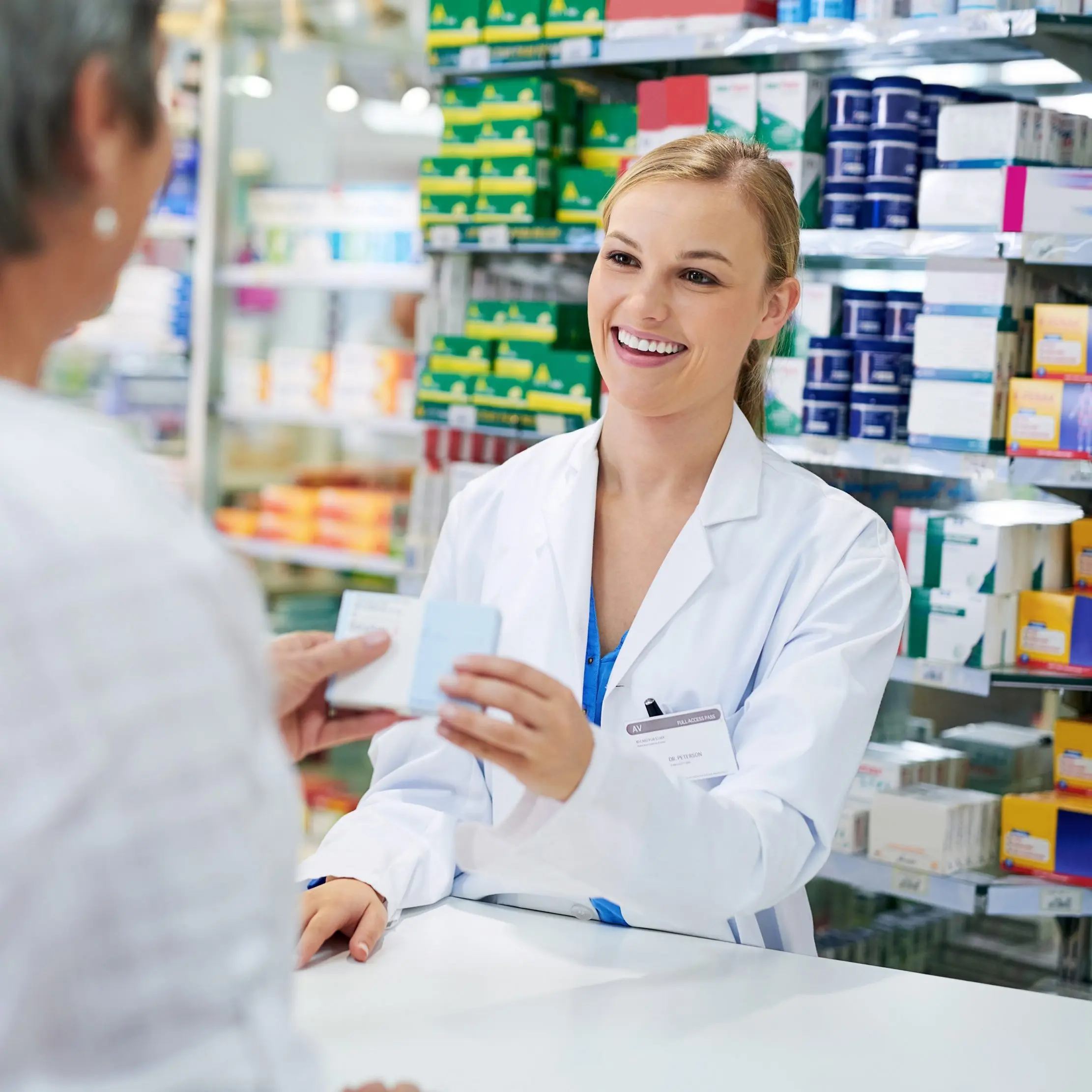 Pharmacienne conseillant une cliente au comptoir, illustrant les workflows Maduuka pour la pharmacie