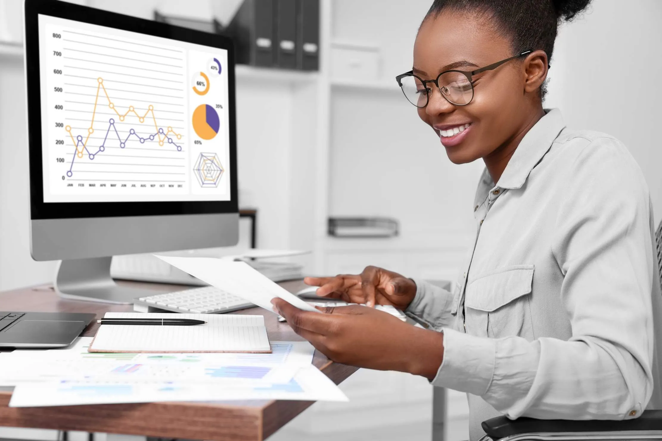 Comptable professionnel revisant des dossiers financiers a un bureau en bois, representant un reporting pret pour l'audit