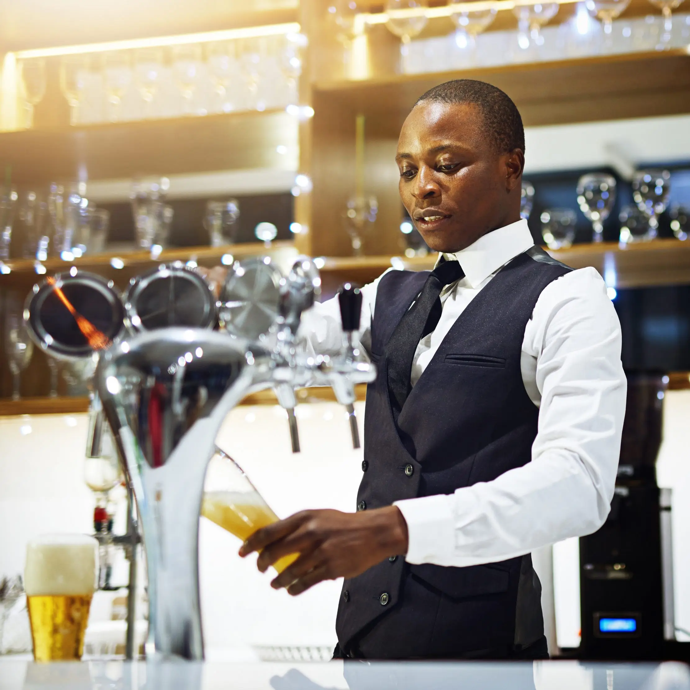 Barman servant une boisson au comptoir, illustrant les opérations Maduuka pour les restaurants et les bars